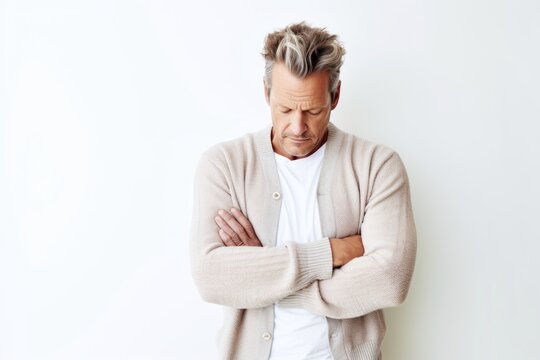 Lifestyle portrait photography of a man in his 40s appearing tired and down due to hypothyroidism wearing a chic cardigan against a white background 