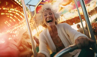 Tuinposter Joyful elderly woman riding in an amusement park © cherezoff