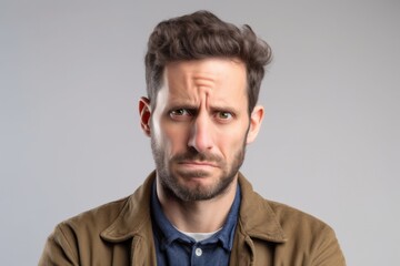 Fototapeta premium Close-up portrait photography of a man in his 30s showing tiredness and a worn-down expression due to chronic fatigue syndrome wearing a chic cardigan against a white background 