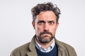 Close-up portrait photography of a man in his 30s showing tiredness and a worn-down expression due to chronic fatigue syndrome wearing a chic cardigan against a white background 
