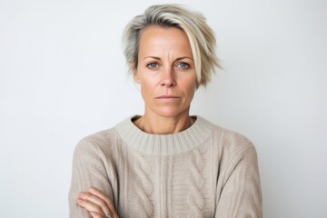 Lifestyle portrait photography of a woman in her 40s showing tiredness and a worn-down expression due to chronic fatigue syndrome wearing a cozy sweater against a white background 