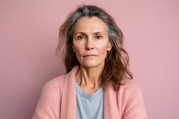 Fototapeta premium Medium shot portrait photography of a woman in her 40s showing tiredness and a worn-down expression due to chronic fatigue syndrome wearing a chic cardigan against a pastel or soft colors background 