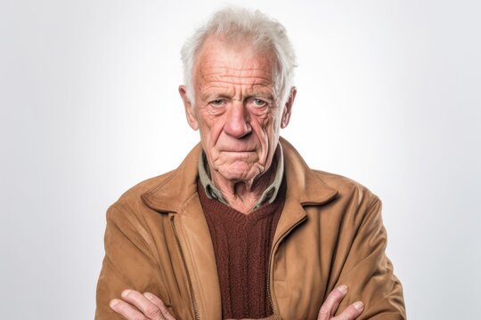 Medium shot portrait photography of a man in his 70s with a trembling hand and pained expression due to Parkinson disease wearing a chic cardigan against a white background 