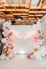 Arch decorated with pink, white and golden balloons, angel wings. Copy space. Celebration baptism...