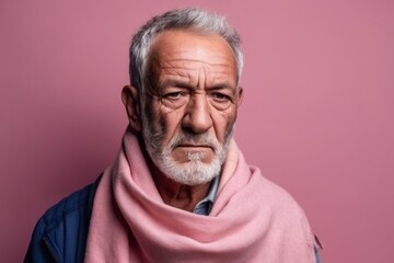 Medium shot portrait photography of a man in his 60s with a somber and deeply sad expression due to major depression wearing hijab against a pastel or soft colors background 