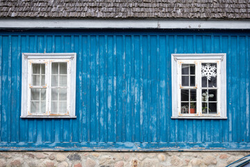 an old white window with a painted blue wooden wall