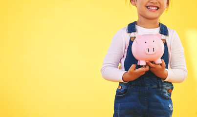 Girl kid, piggy bank and saving in studio with smile, mockup space and excited by yellow...