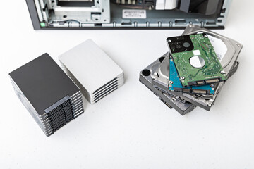 Closed-up view of hard disk drives with a PC in the background. Upgrade, repair and data recovery...