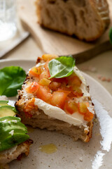 Salmon toasts with sourdough bread, sliced avocado, cream cheese and basil