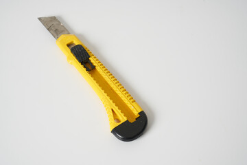 Yellow utility knife on an isolated background