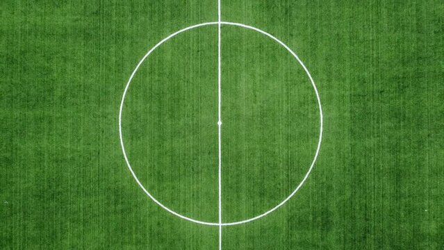 4k aerial top view of empty new football field with running tracks - zoom out from centre of the field