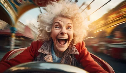 Foto auf Leinwand Joyful elderly woman riding in an amusement park © cherezoff