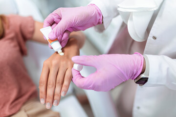 Doctor applying protective cream on patient's hands