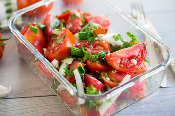 Spicy snack tomatoes with garlic, herbs, seasonings and onions in a glass bowl .