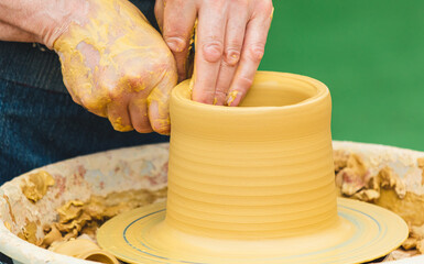 Clay craftsman sculpts crockery . Close-up.