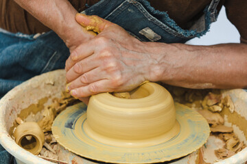 Clay craftsman sculpts crockery . Close-up.