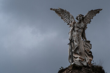 Ancient victorian statue of Destroyer Angel at a graveyard with dark sky. Statue of Abbadon from...
