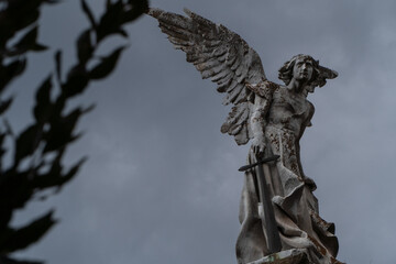Ancient victorian statue of Destroyer Angel at a graveyard with dark sky. Artist: Josep Limona Date: 1895 Place: Comillas old cemetery, Spain