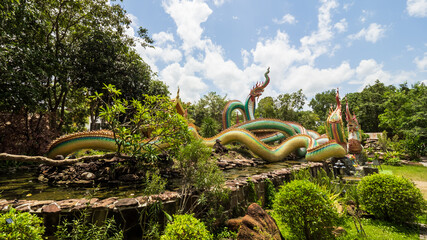 Ubon Ratchathani, THAILAND - August 8, 2023: Buddhist travel glowing serpent statue with sunlight...