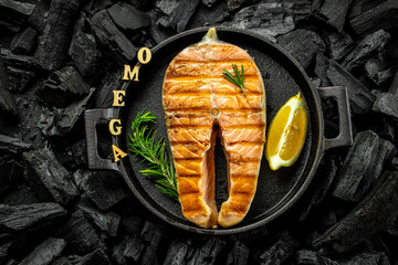 grilled salmon steak on BBQ grill coal. Keto diet concept healthy food, top view