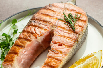 Fresh cooked delicious salmon steak with spices and herbs baked on a grill. Restaurant menu, dieting, cookbook recipe top view