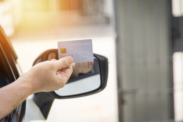 Closed up hand use credit card on car to pay for fuel