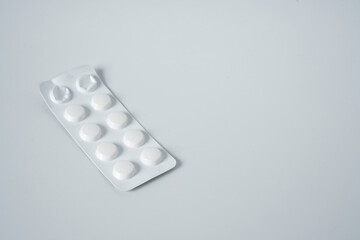 Painkillers or drugs in plastic box on a white surface.