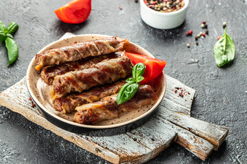 grilled rolls of minced meat wrapped in bacon. Delicious balanced food concept