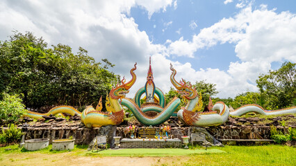Ubon Ratchathani, THAILAND - August 8, 2023: Buddhist travel glowing serpent statue with sunlight at Wat Pa Phu pang temple, Si Chiang Mai District, Ubon Ratchathani Province, Thailand. - obrazy, fototapety, plakaty
