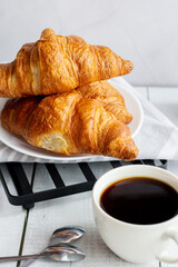 A cup of coffee and croissants. on white wooden. breakfast. Morning