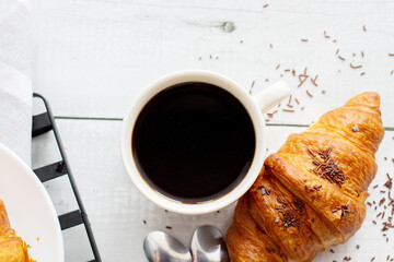 A cup of coffee and croissants. on white wooden. breakfast. Morning