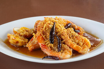 Deep Fried Shrimp with Tamarind Sauce in white plate on the brown wooden table in the restaurant.