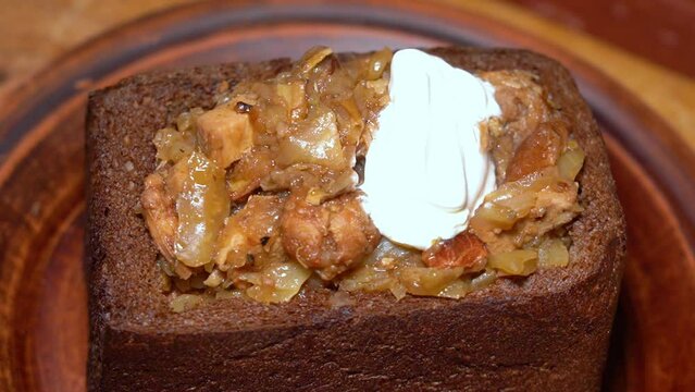 Bigos food in the black bread and sour cream. Traditional Polish dish of sauerkraut and meat