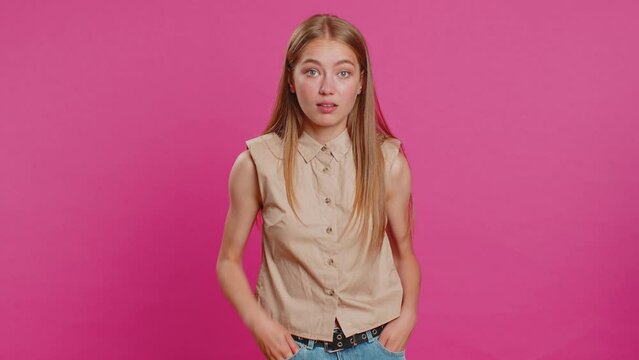 Cheerful funny young woman showing tongue making faces at camera, fooling around, joking, aping with silly face, teasing, bullying, abuse. Girl isolated alone on pink studio background. Lifestyles