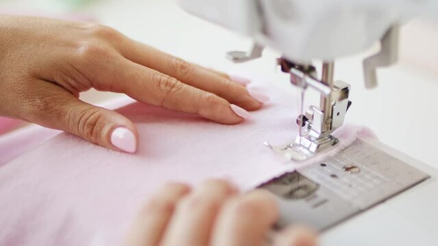 Woman clothing designer sews fabrics on a sewing machine. Needlework and handmade patchwork hobby.	