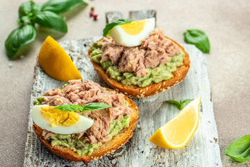 sandwiches with canned tuna, boiled egg and avocado. Food recipe background. Close up