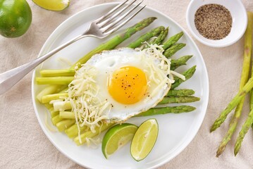 Boiled asparagus with fried egg and black pepper. Healthy breakfast