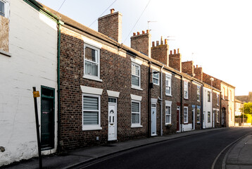 Run down terraced houses with sunlight at the end of the street