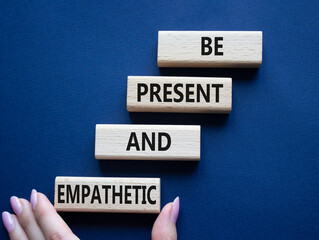 Be Present and Empathetic symbol. Concept words Be Present and Empathetic on wooden blocks. Businessman hand. Beautiful deep blue background. Business concept. Copy space