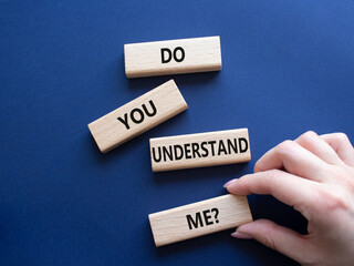 Do you understand me symbol. Concept words Do you understand me on wooden blocks. Beautiful deep blue background. Businessman hand. Business and Do you understand me concept. Copy space.