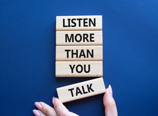 Listening skills symbol. Concept words Listen more than you Talk on wooden blocks. Businessman hand. Beautiful deep blue background. Business and Listen more than you Talk concept. Copy space