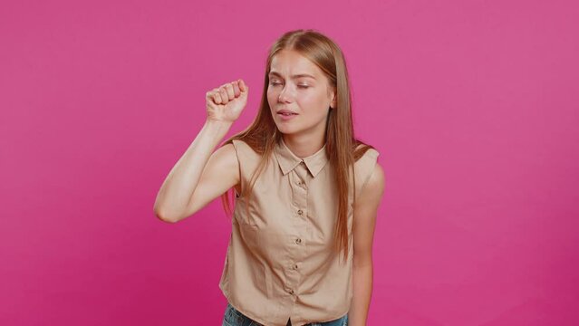 Knock-knock who is there. Excited young woman knocking door gesture asking who is at home, feeling embarrassed, no idea, being clueless and uncertain. Girl isolated alone on studio pink background