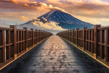 Mount Fuji with misty clouds passing by and a wooden bridge.