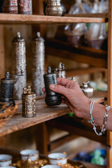 Metal tea and coffee sets on the shelf in the store. Woman taking a cezva from the shelf.