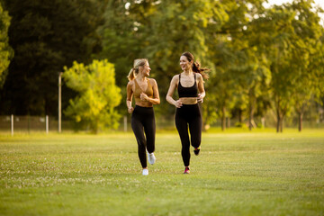 Two pretty young women running in the park