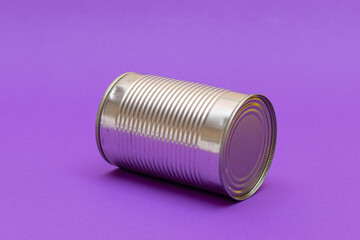 Unopened Tin Can with Blank Edge on Violet Background. Canned Food. Aluminum Can for Safe and Long Term Storage of Food. Steel Sealed Food Storage Container