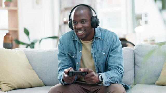Man, headphones and video game with controller, sofa and excited for virtual user experience, streaming or esports. Young guy, online gaming and thinking with press, click and strategy for challenge