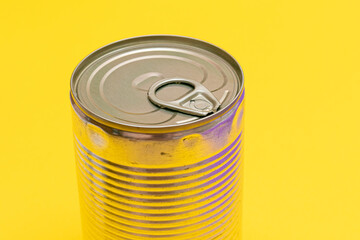 Unopened Tin Can with Blank Edge on Yellow Background. Canned Food. Aluminum Can for Safe and Long Term Storage of Food. Steel Sealed Food Storage Container
