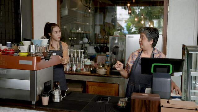 Asian female senior single mom Called my daughter to look at the online cash register, lots of drink orders coming in, beautiful Asian baristas. owner's daughter is happy and hugs her mother happily..