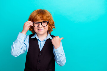 Photo of intelligent cute little boy arm touch eyeglasses direct thumb finger empty space ad isolated on teal color background